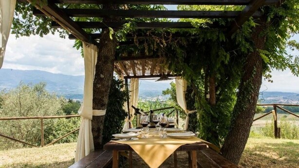 A table set for two with a view of the countryside.