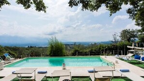 A swimming pool with lounge chairs and a view of the landscape.