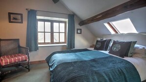A bedroom with a large bed, a chair, a window, and a skylight. - Perfect for  all large groups in 7 all ensuite bedrooms . Pet friendly (Buxton)