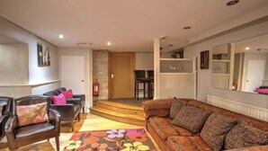 A living room with a sofa, chairs, a coffee table, and a fireplace. There is a staircase leading to an upper level. - Perfect for  all large groups in 7 all ensuite bedrooms . Pet friendly (Buxton)