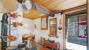 A rustic kitchen with a wooden ceiling, a stone wall, and a large window. - Rustico Stock With Free Wifi (Monteceneri)