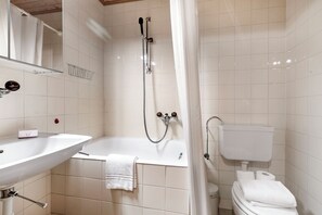 A bathroom with a sink, bathtub, shower, toilet, and a mirror. - Rustico Stock With Free Wifi (Monteceneri)
