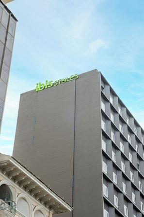 Un edificio alto con el letrero "ibis styles" en la parte superior.