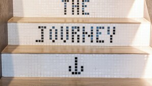 Una escalera con mosaicos que deletrean "SIGUE TUS SUEÑOS Y DISFRUTA EL VIAJE".