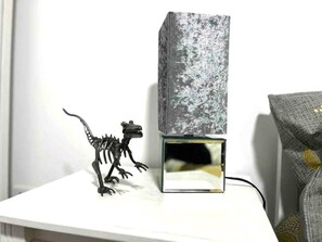 Simple, modern room with a desk, mirror, and decorative piece.