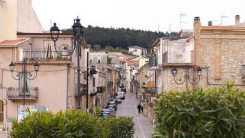 Una stretta via fiancheggiata da edifici tradizionali, con balconi e lampioni.