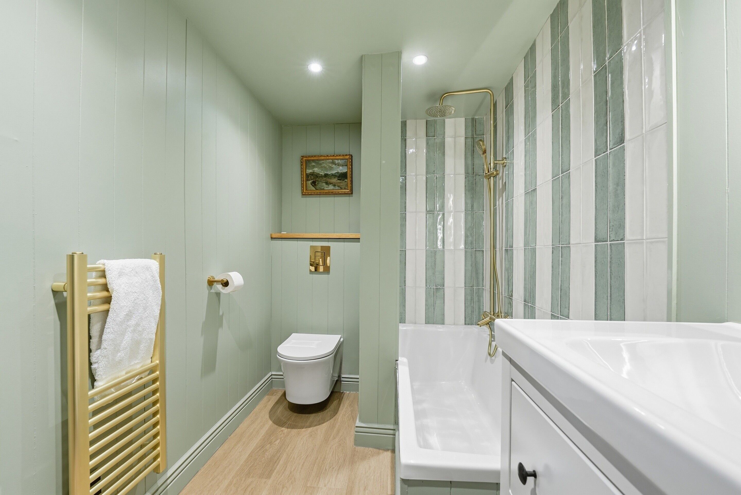 Un bagno con un water, un porta asciugamani, una doccia con porta in vetro e una vasca da bagno.