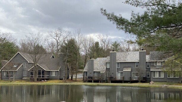 A lakeside property with two-story buildings, a dock, and a calm lake. - Fishing, skiing, golfing, water parks, restaurants, outlets  , family activity (Blakeslee)