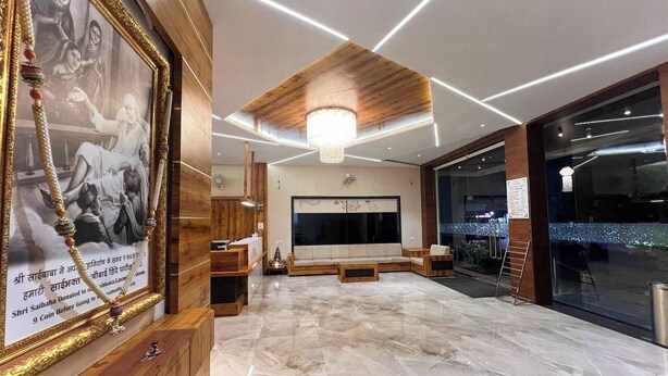 Um hall amplo com piso de mármore, mobiliário de madeira e uma grande moldura na parede.