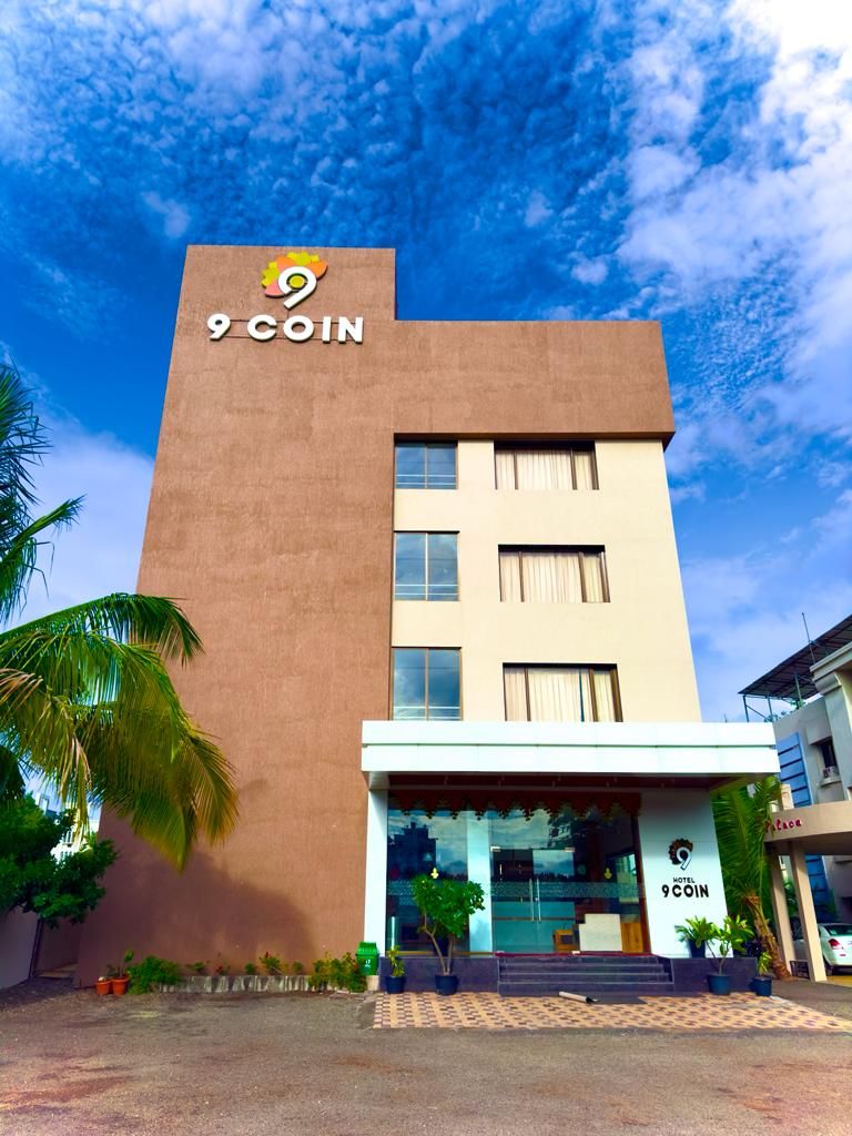 A hotel building with a sign reading '9 COIN' and a logo above the entrance.
