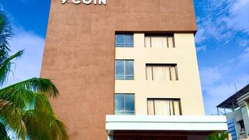 A hotel building with a sign reading '9 COIN' and a logo above the entrance.