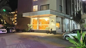 Um hotel com um destaque para o letreiro '9 COIN', design arquitetônico moderno e entrada bem iluminada.