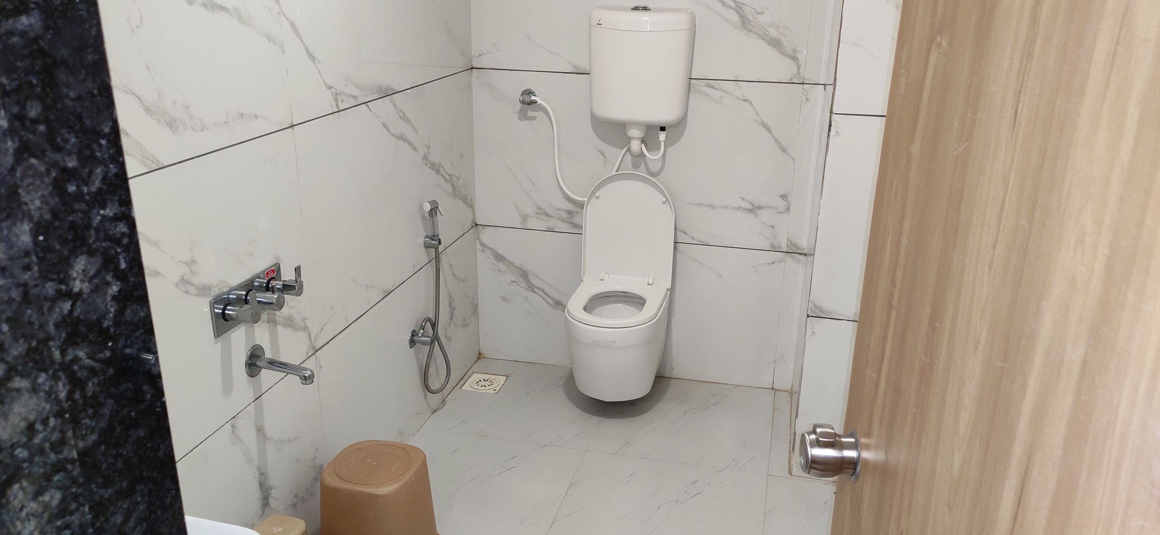 A bathroom with a toilet, bidet, and shower.