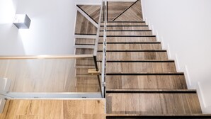 Una escalera moderna con escalones de madera y barandillas de metal.