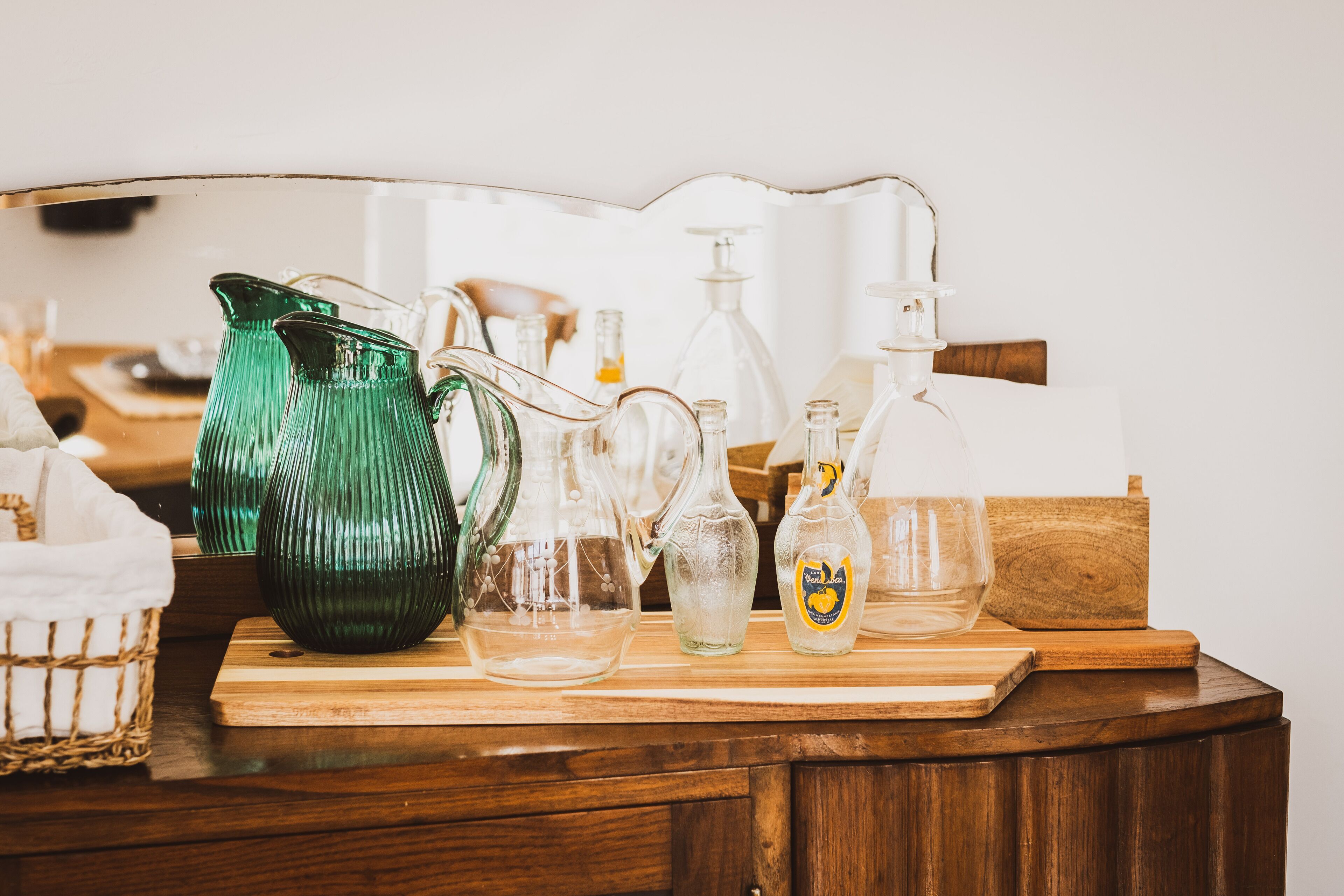 Un comptoir en bois, sur lequel on trouve divers récipients en verre et une bouteille de gel hydroalcoolique.