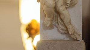A marble statue of a cherub leaning against a column. - Viareggio Sea & Garden (Viareggio)