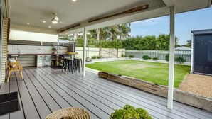 A covered outdoor area with a barbecue, seating, and a view of a well-maintained lawn and trees. - Shepherds Delight-Disabled/Access Friendly (Goolwa South)