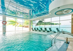 Una piscina interior con vistas despejadas al océano y un paisaje tropical.