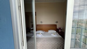 Una habitación de hotel con una cama, una mesita de noche y una ventana.