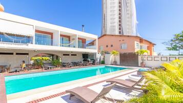 Alberca al aire libre y camastros