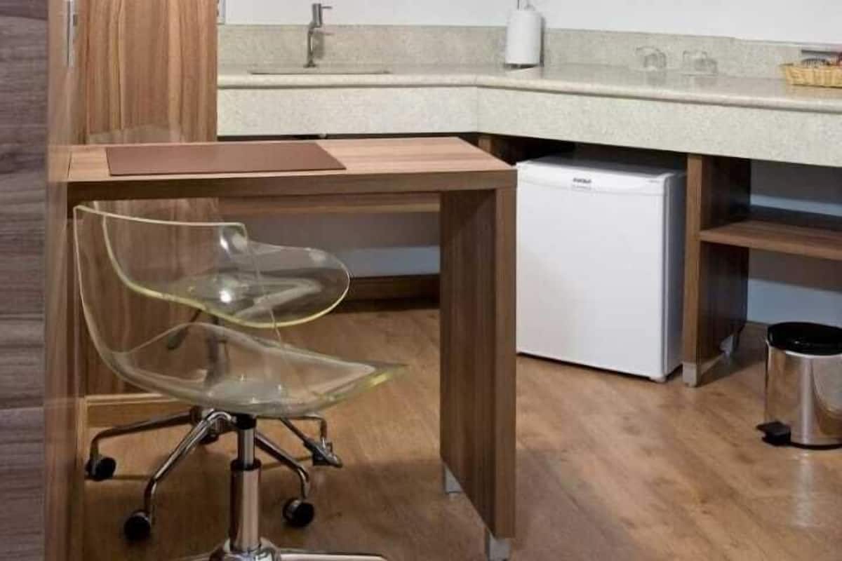 Een moderne keuken met een houten aanrecht, een ingebouwde magnetron en een roestvrijstalen prullenbak.