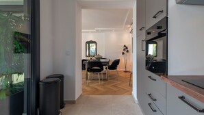 A modern kitchen with grey cabinets, a wooden countertop, and a built-in oven.