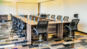A conference room with a long table, multiple chairs, and water bottles. - Ambrosia Hotel (Naivasha)