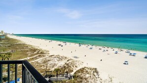 A beach with clear turquoise waters, sandy shore, and beach umbrellas.