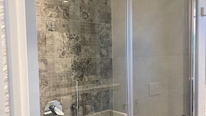 A modern shower enclosure with a glass door and patterned tiles. - Beachfront apartment with fantastic terrace facing the Ionian Sea (Ardore Marina)