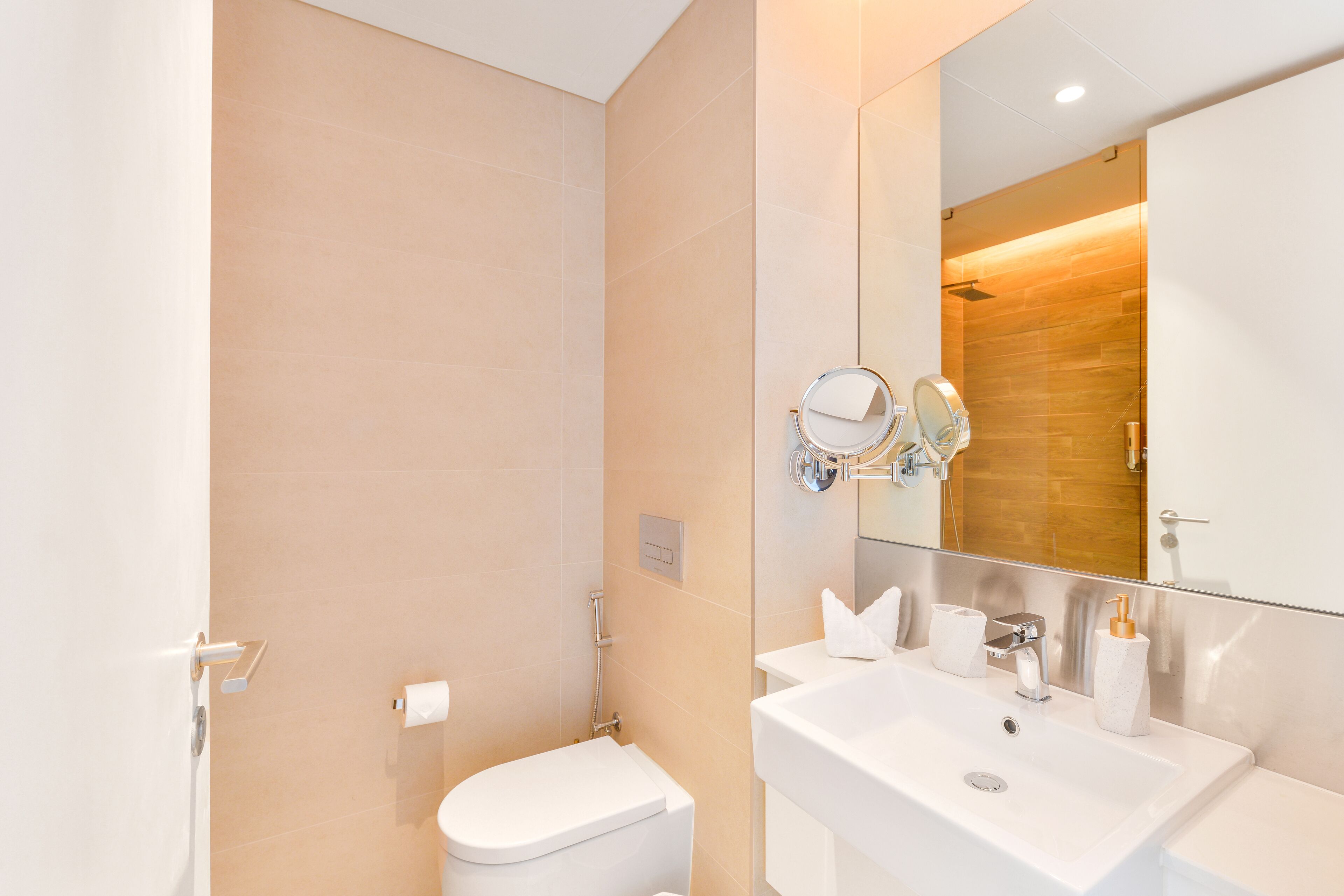 Ein modernes Badezimmer mit Toilette, Waschbecken und Spiegel.