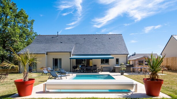 Un jardin avec une piscine, des meubles de jardin et des plantes en pot.
