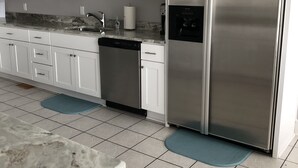 A modern kitchen with white cabinets, a stainless steel refrigerator, and a dishwasher. - Bay View Bungalow by the Pier - Swimming Pool and Pet Friendly - 30 Day Listing (Norfolk)