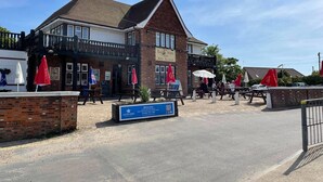 A traditional pub with a brick facade, outdoor seating, and red umbrellas. - M & T Chalets , Detached Modern 2 bed Chalet, Sleeps 6 (Hemsby)