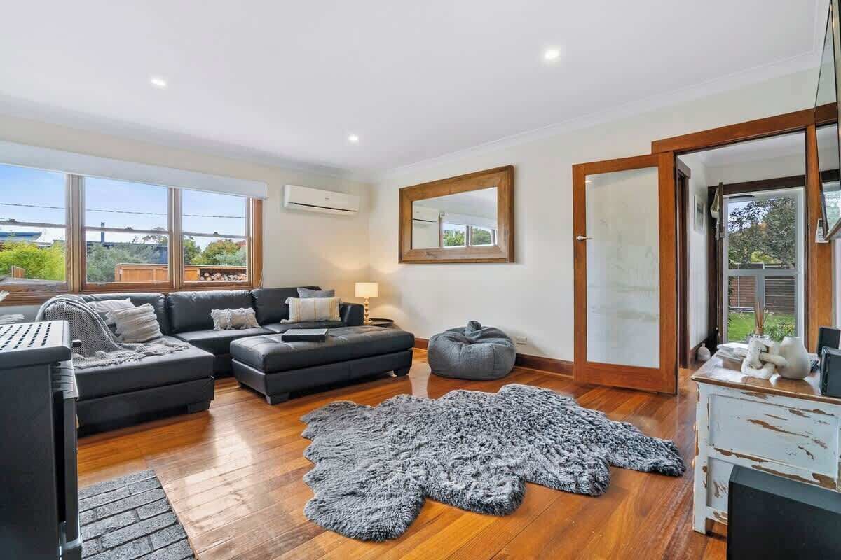 A modern living room with a sectional sofa, a grey shag rug, and a wooden coffee table.