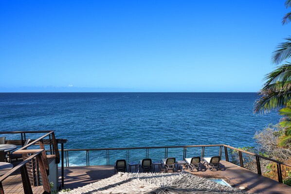 A deck with chairs and tables overlooking a large body of water. - Direct Ocean Front - Renovation Complete - EVERYTHING inside is NEW! (Koloa)