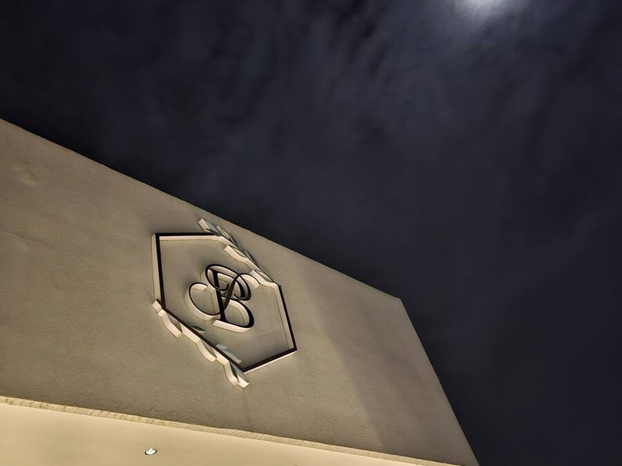 A building with a prominent logo on the facade and a moon in the sky.