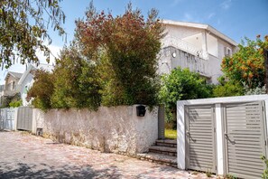 A residential building with a stone facade, a gated entrance, and a brick pathway. - private vacation home in ?????? (הרצליה)