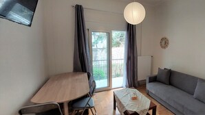 Ein Wohnzimmer mit grauem Sofa, einem Holztisch und einer weißen Tischdecke.