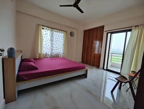 Relax in this cozy retreat with a single bed, ceiling fan, and balcony view.