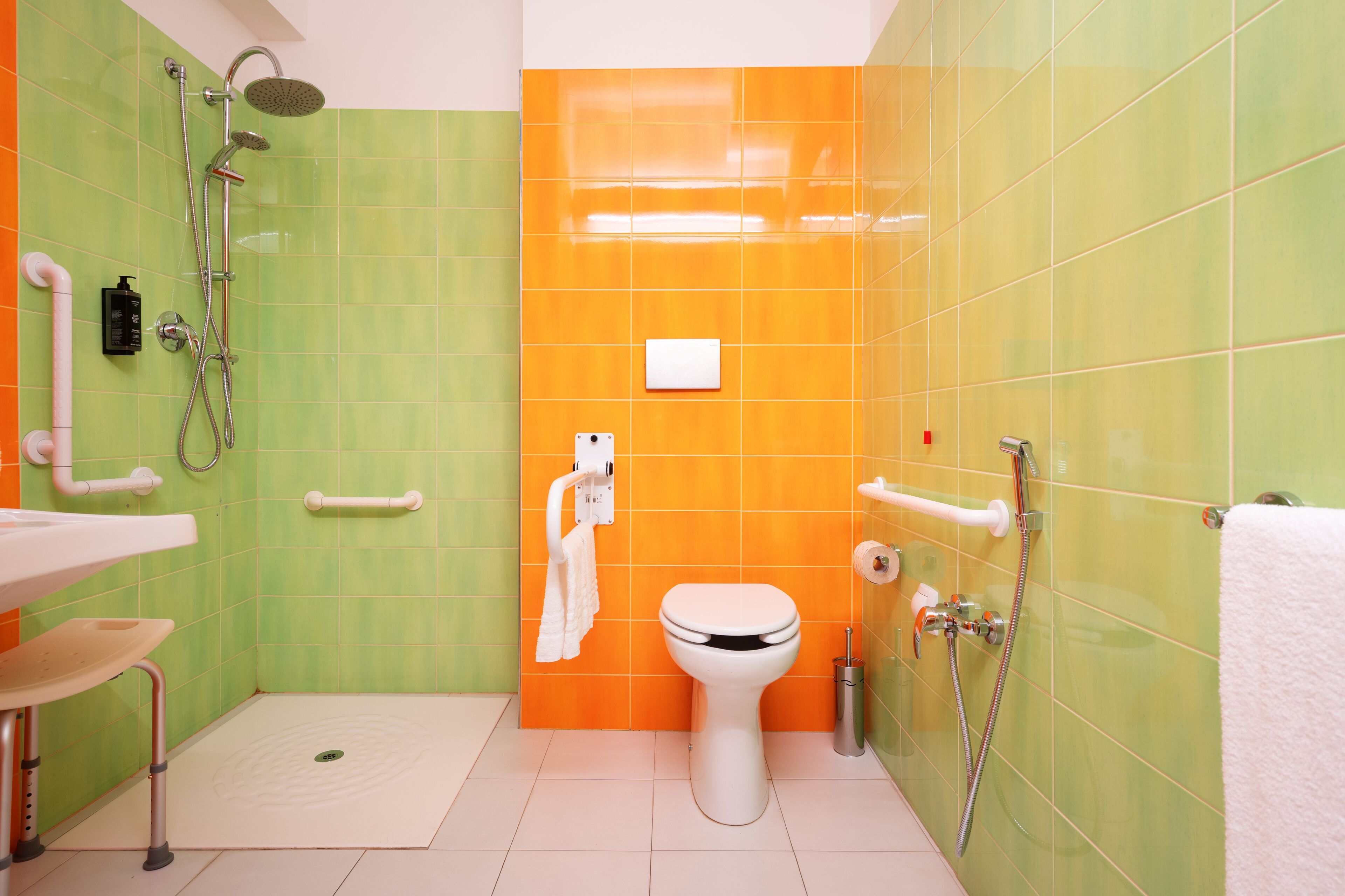 A bathroom with a white toilet, a shower, and a sink.
