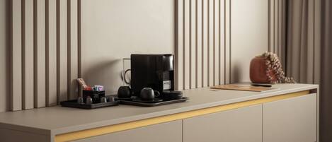 A modern kitchen with a coffee machine, a tray with cups, and a decorative vase.