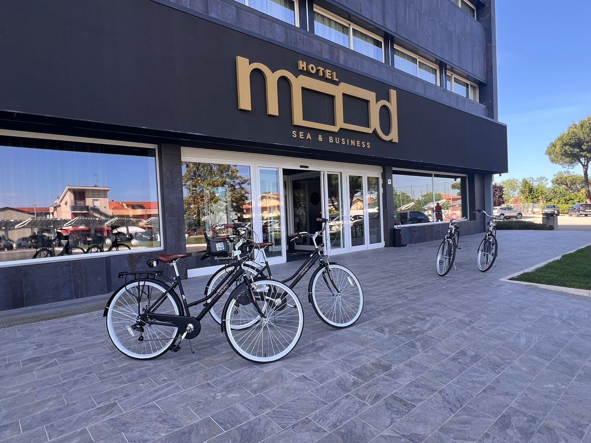 A modern building with a sign reading "MOMOD HOTEL SEA & BUSINESS".