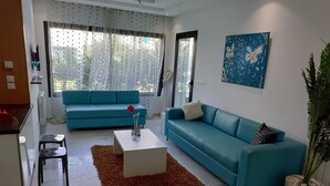 Un salon moderne avec un canapé bleu, une table basse et une plante en pot.