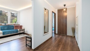 Een moderne woonkamer met een bank, een bijzettafeltje en een groot raam.