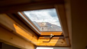 Um claraboia com vista para uma montanha e um edifício.