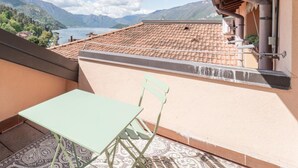 Uma varanda com vista para montanhas e um lago.