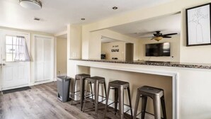 A kitchen with a white countertop, four bar stools, a ceiling fan, and a door with a window. - FIFA 2026 HQ: Family Affair in Philly Suburbs - Free Parking (Clifton Heights)