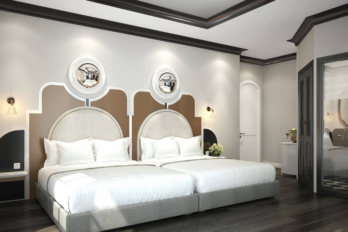A modern bedroom with a large bed, two wall sconces, and a door with a mirror.