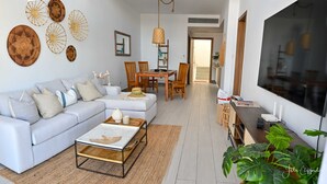 A modern living room with a sofa, coffee table, and dining area. - Luxurious Chic Penthouse Navio Beach (Punta Cana)