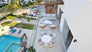 A rooftop pool area with lounge chairs, a table, and umbrellas. - Luxurious Chic Penthouse Navio Beach (Punta Cana)